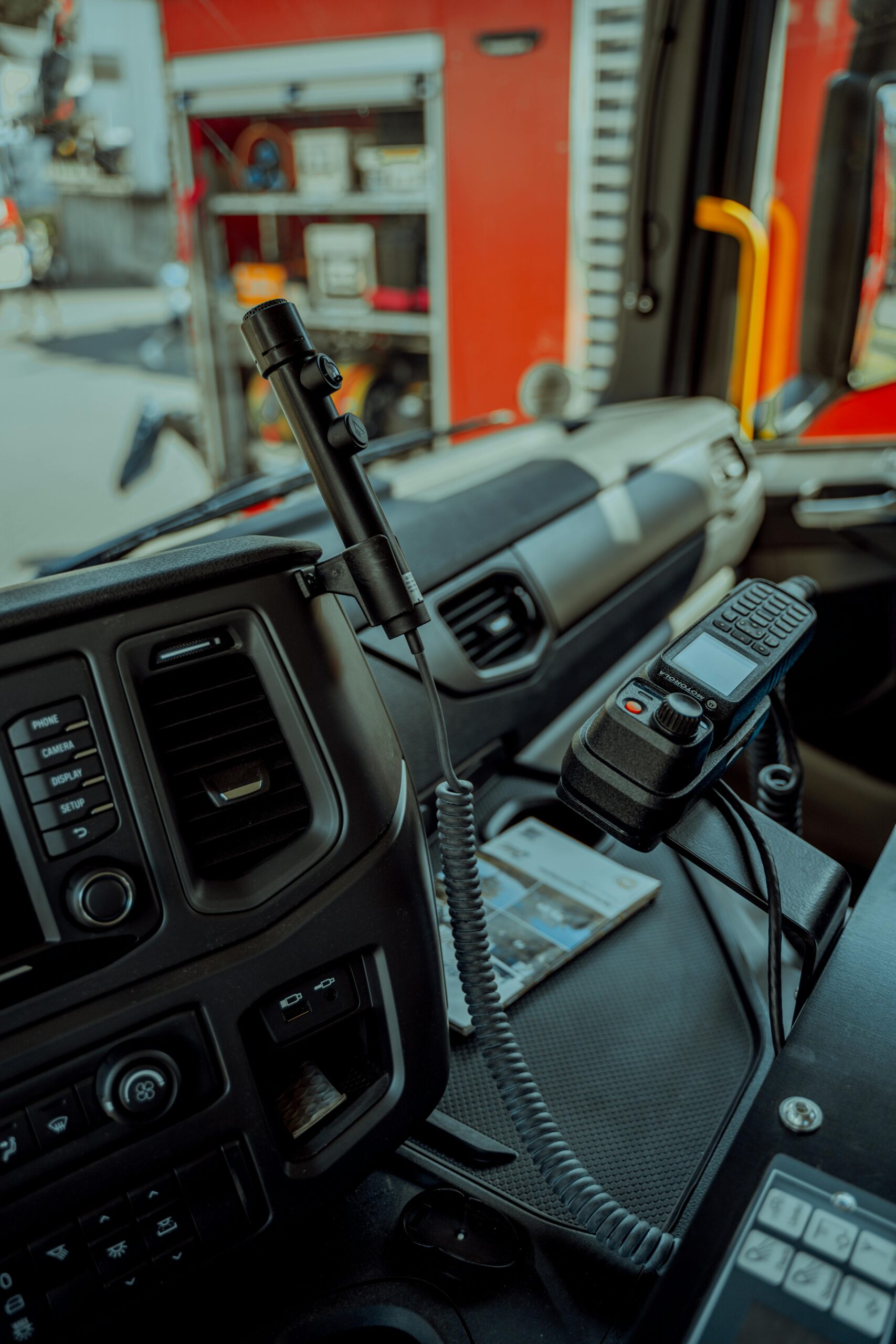 Close-up of a fire truck interior showcasing dashboard and communication devices.